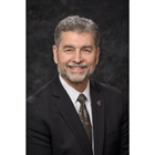 Dr. Juhasz smiles in front of dark gray background.